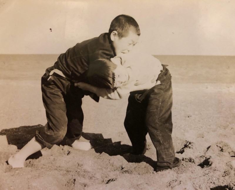 湧別の浜で弟と相撲をとる島崎さん（左）