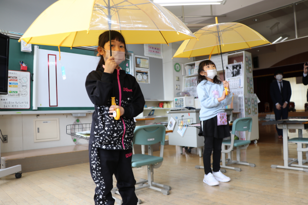 黄色い傘をさす2人の女の子