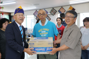 飲み物を手渡す関野会長