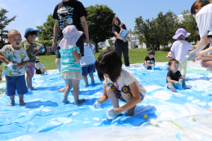 真っ白な紙に海や空をイメージして絵の具を塗る子どもたち