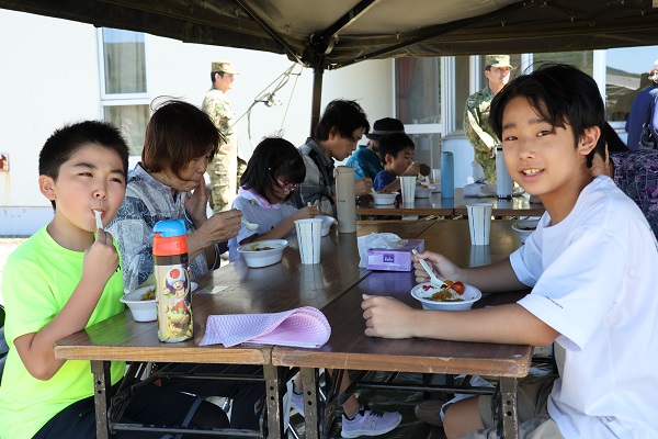 炊き出しのカレーを食べる様子