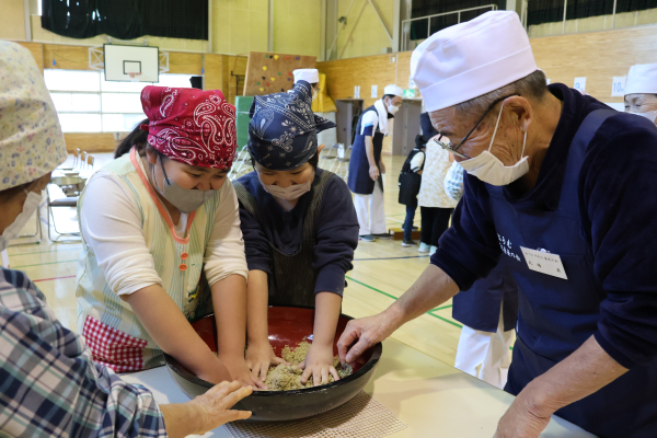 指導を受けながらそば粉を練る児童たち