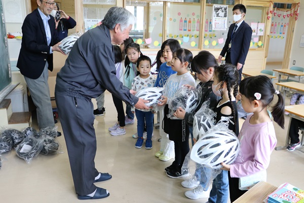 佐藤支部長からヘルメットを贈呈される児童たち