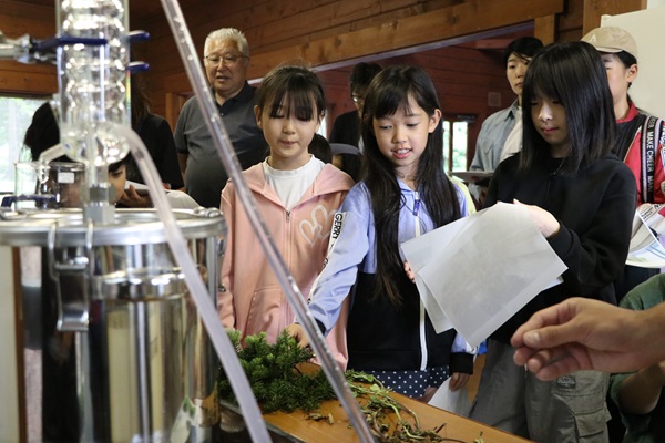 蒸留装置の説明を受ける参加者