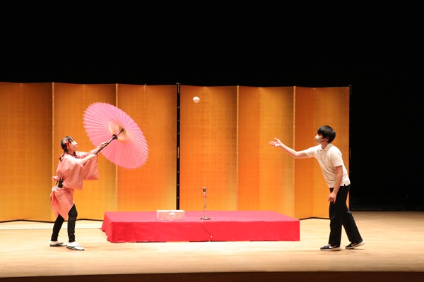 傘回し芸の手伝いを体験する生徒