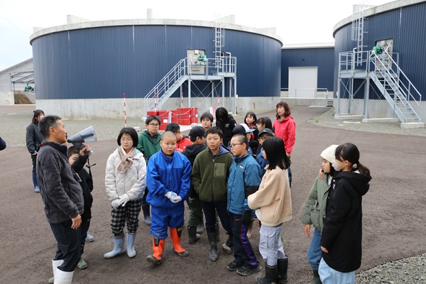 バイオガスプラントの説明を聞く児童たち
