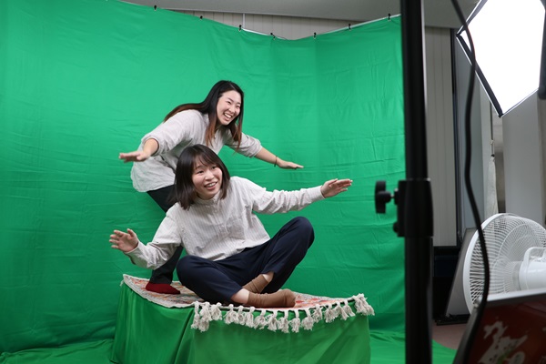 じゅうたんに乗ってポーズをとる参加者