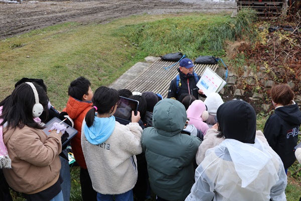 湧別川に生息するサケの仲間やその生態について説明を受ける児童ら