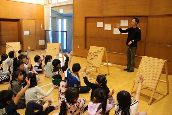 「森のピタゴラス」について説明を受けるこどもたち