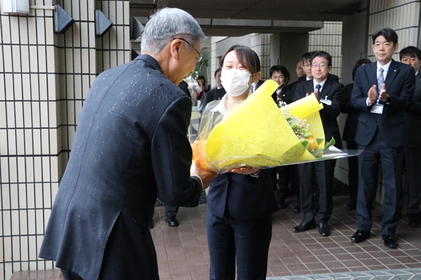 庁舎玄関で職員から花束を受け取る加藤町長
