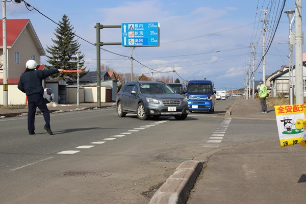 交通安全運動該当啓発にて車を誘導する様子