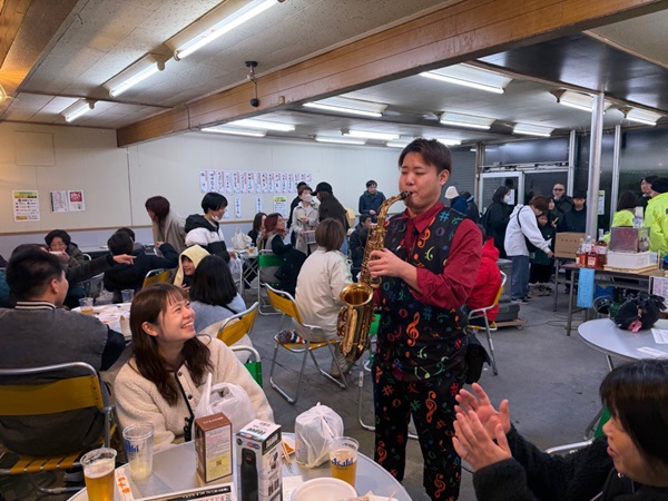 各テーブルを回りながらサックス演奏するパフォーマー