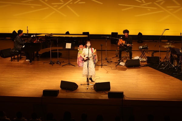 ウクレレを引きながら歌う様子