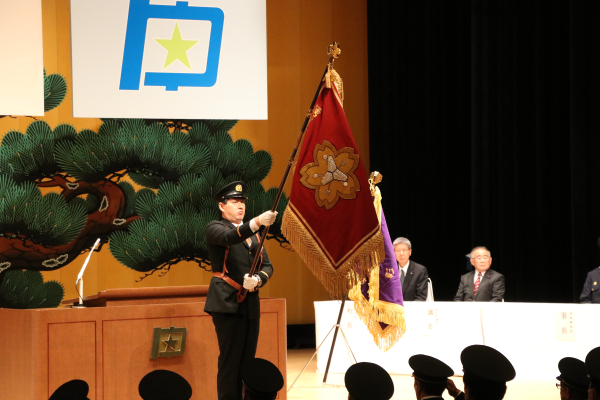 団旗に敬礼する団員ら