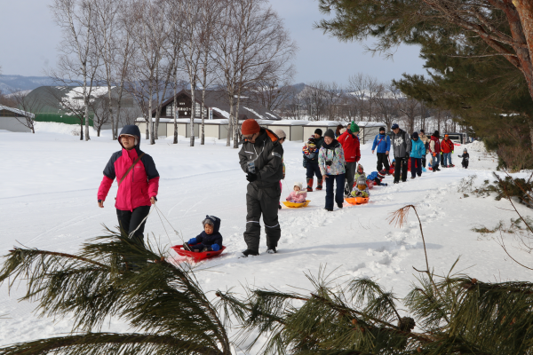 そりに乗って引かれながら五鹿山公園に向けて出発