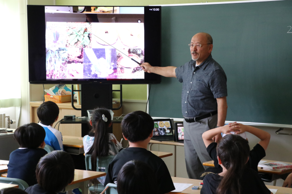 上湧別学園で画面に映る写真を使いながら説明する絹張講師