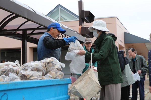 自治会から住民へホタテを渡している様子