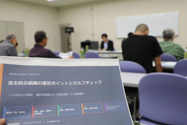 講座資料と説明を聞く参加者