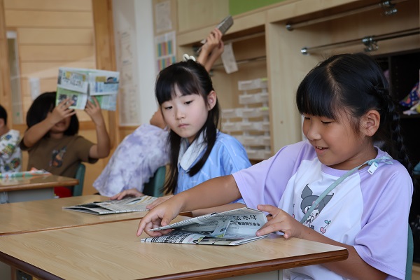 新聞紙でスリッパを作る様子