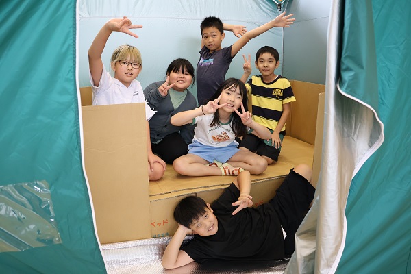 ダンボールベッドを体験する様子