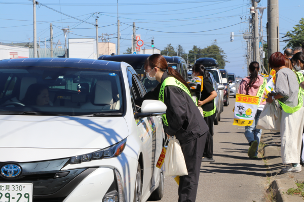 通行する車を呼び止めて交通安全を呼びかける参加者